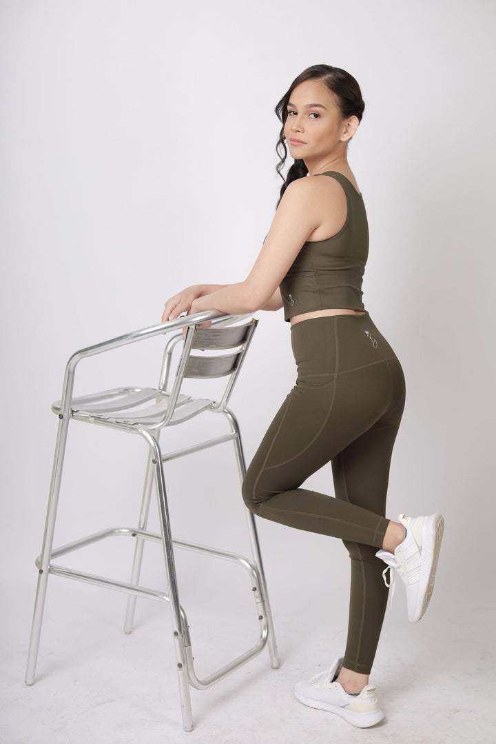 A lady wearing Beauty Lyfe Activewear Elisse Model Olive Green Leggings and in sports bra