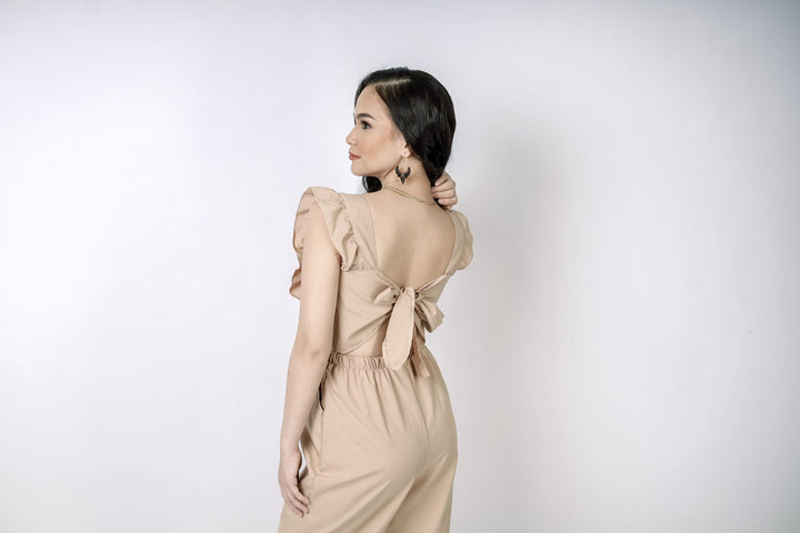 A lady wearing Beauty Lyfe Dress Sandra Ruffles Romper Jumpsuit Pants in Nude Color Model