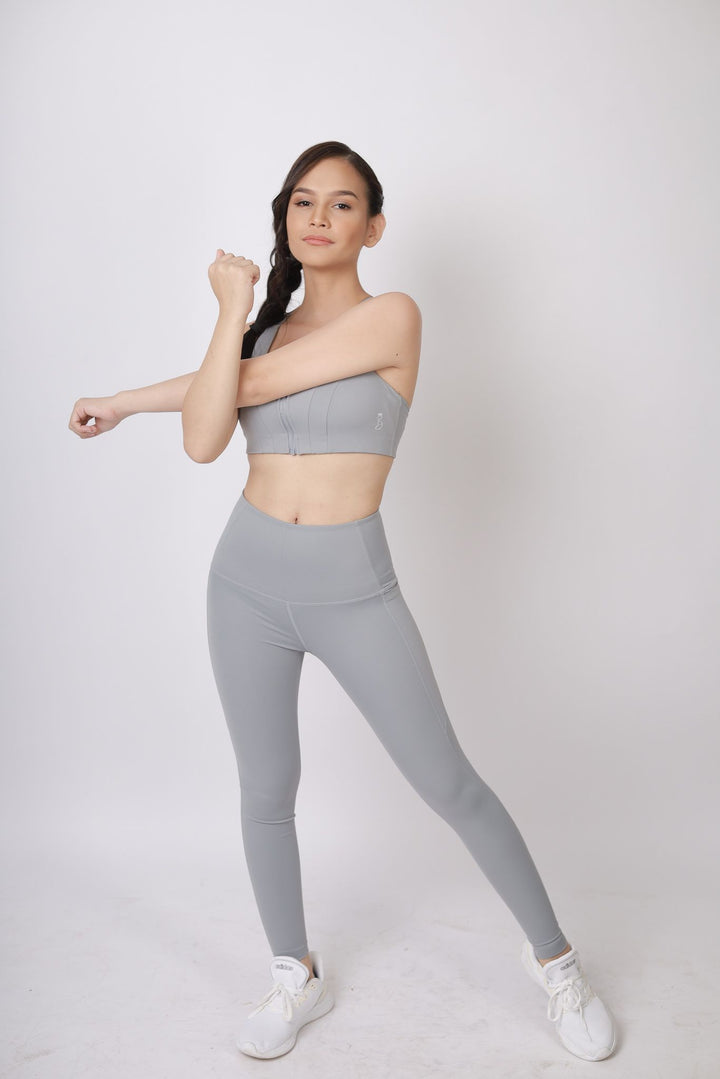 A lady wearing Beauty Lyfe Activewear Gracie Model Gray sports bra and in leggings